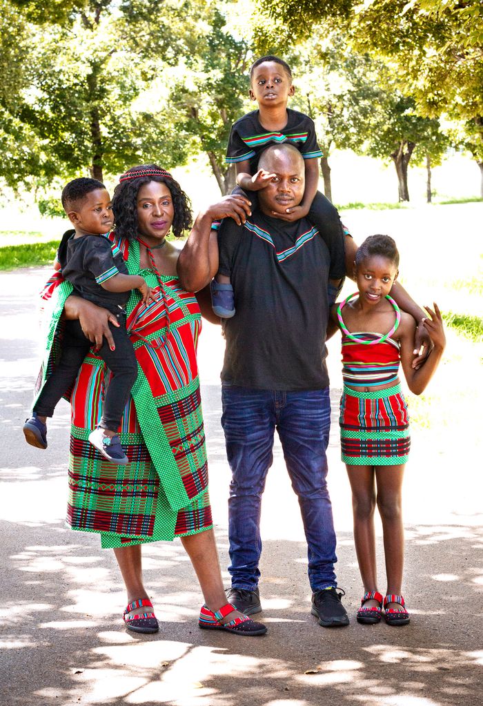 A joyous family posing outdoors in traditional African clothing, enjoying quality time together.
